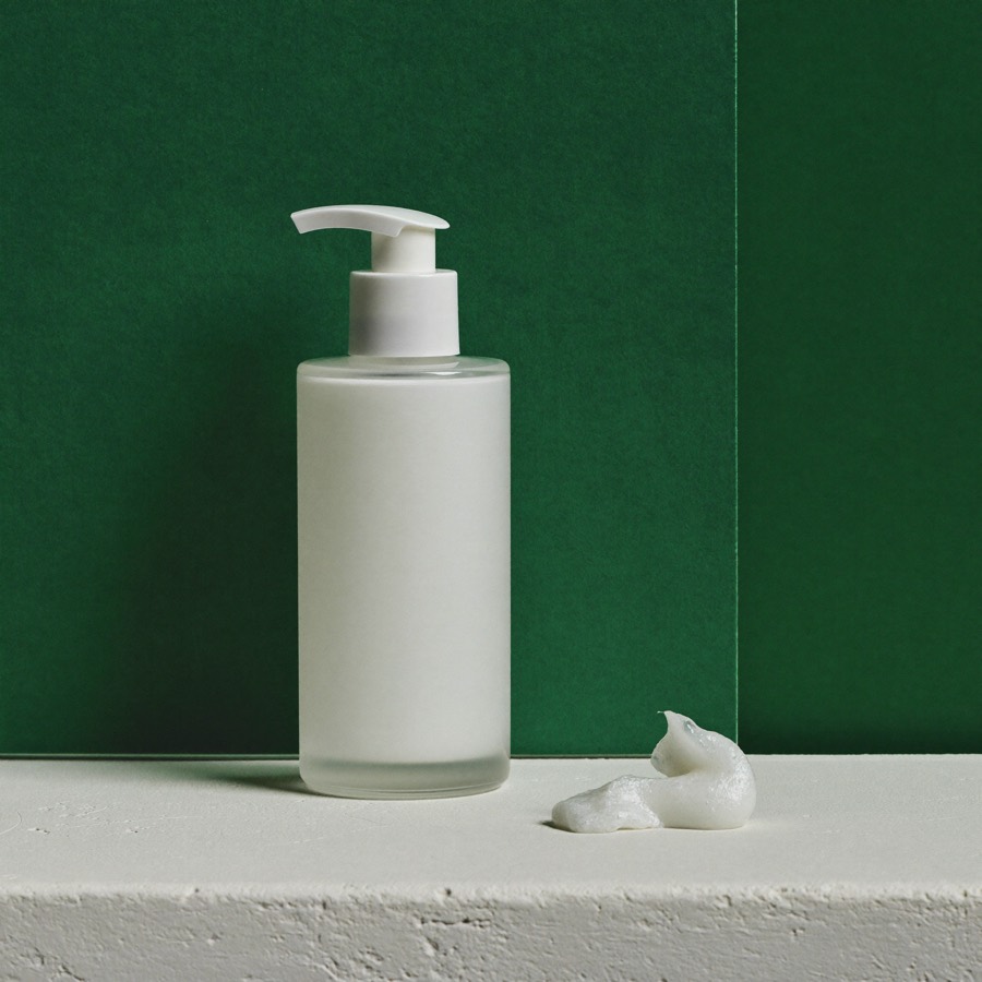 Flacone bianco con dosatore del Detergente Delicato Zagara su fondo verde